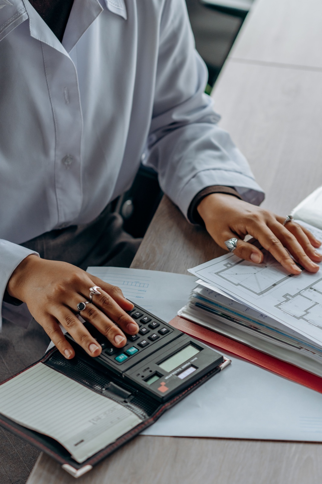 Persona usando una calculadora para organizar sus medios económicos y documentos
