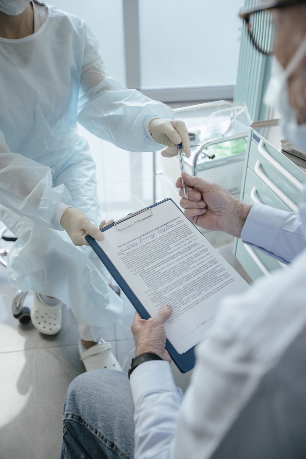 Profesional sanitario revisando y firmando documentación con un paciente